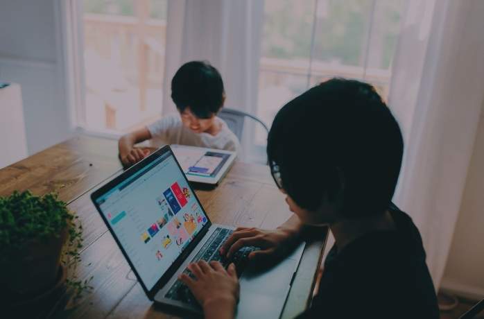 two Asian kids accessing learning materials from home